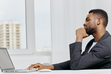 Business professional focused on work, analyzing data on a laptop at a modern office desk