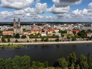 Fototapeta premium Shot of Magdeburg city center with cathedral and river Elbe. Tree-lined banks and cloudy sky over the city. Travel destination in Saxony-Anhalt Germany.