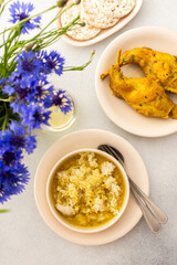 Stewed rabbit with rice, broccoli and rice cakes, a served table with food and a vase of flowers, a...