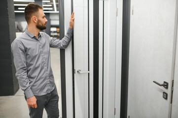 A man chooses doors in a hardware store for his apartment