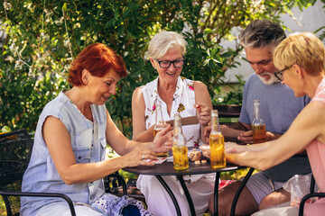 Group of elderly retired people playing bingo outside. Drinking beer and enjoying some time outside.