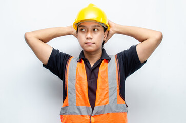 Title	
young asian man construction worker using yellow helmet and orange vest makes a thinking gesture. asian male worker in pensive expression while thinking looking for idea.