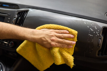 A detailed process of cleaning a car using a yellow cloth for optimal cleanliness and shine