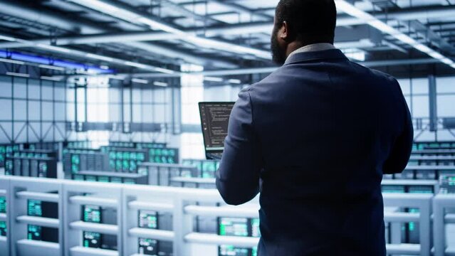 African american admin in data center running error checking utilities on tablet to fix hardware bugs. IT expert in server hub workspace looking for issues affecting mainframes performance, camera B