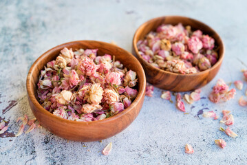 Flower tea rose buds in wooden bowl