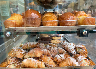 Traditional Italian dessert baba and croissants in window display in Naples , Italy.