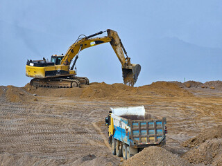 Excavator and dump truck type construction machinery building earth platform.