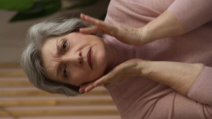 Vertical Screen: A close-up portrait of a gorgeous, beautiful middle-aged woman, 60 years old, touching her smooth, healthy skin. The concept of anti-aging, skin care, cosmetics, spa, body care