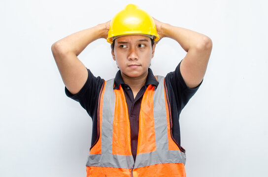 Asian male construction worker in hardhat and orange vest looks sad with crying gesture. stressed overworked concept. workers' insurance concept.