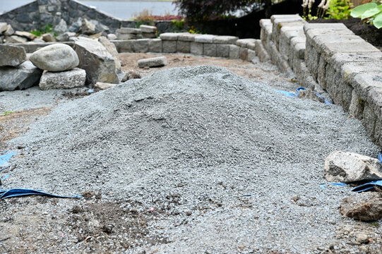 Yard and garden building project, terracing sloped patio space with stone and rock walls for flower and vegetable beds.