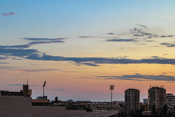 Naklejka premium Cityscape of Novi Sad, Serbia at sunset, showcasing the skyline of the stadium and residential buildings under a colorful sky