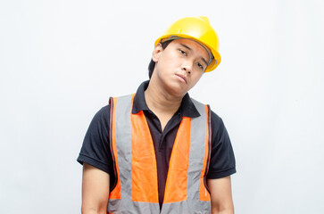 overworked concept illustrated by a sleepy construction worker yawning with hand gestures covering...