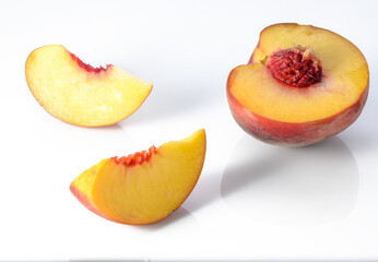 Peach isolated. Whole peach with a slice on white background. Peach fruit with leaf and cut pieces. Full depth of field.