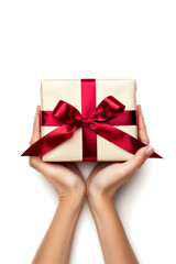 Woman holding gift with red ribbon on white background overhead view
