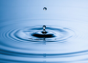 Blue Water drop falling, macro splash. Natural background