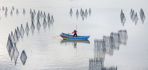 silhouette of a boat at the seaside with fishing and seaweed nets