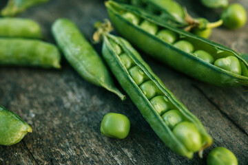 Green Peas. Green background. Green pea top view copy space. Fresh organic green peas. Vegetable harvesting. Beautiful close up of fresh peas and pea pods. Healthy vegetarian food