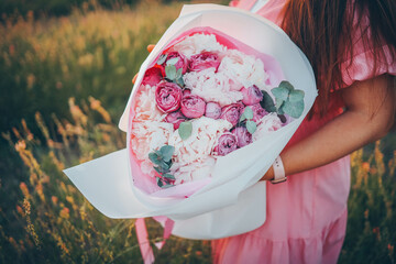 Girl with a large bouquet of peonies girl in nature