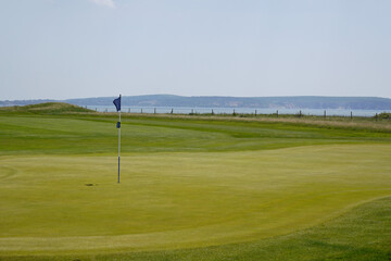 golf course with sea view. golf hole green with flag. sport and leisure activities 