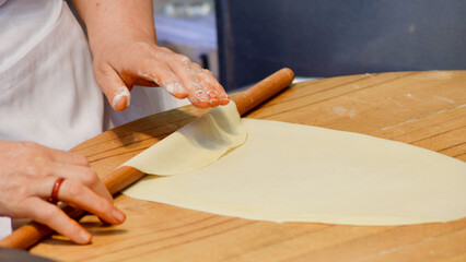 Local woman rolling dough with a rolling pin