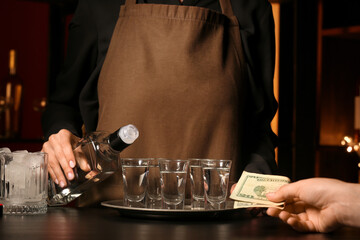 Client paying for shots of vodka in bar