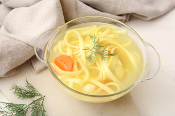 Pot of tasty chicken soup on white wooden background