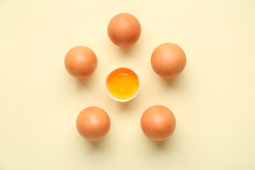 Raw chicken eggs on yellow background