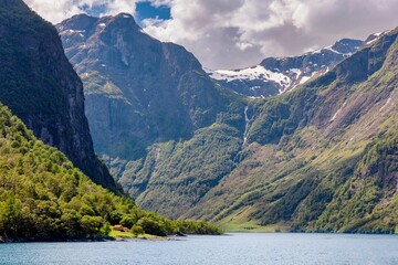 Picturesque landscape of a lush green valley with  mountains, and a blue sky in Norway