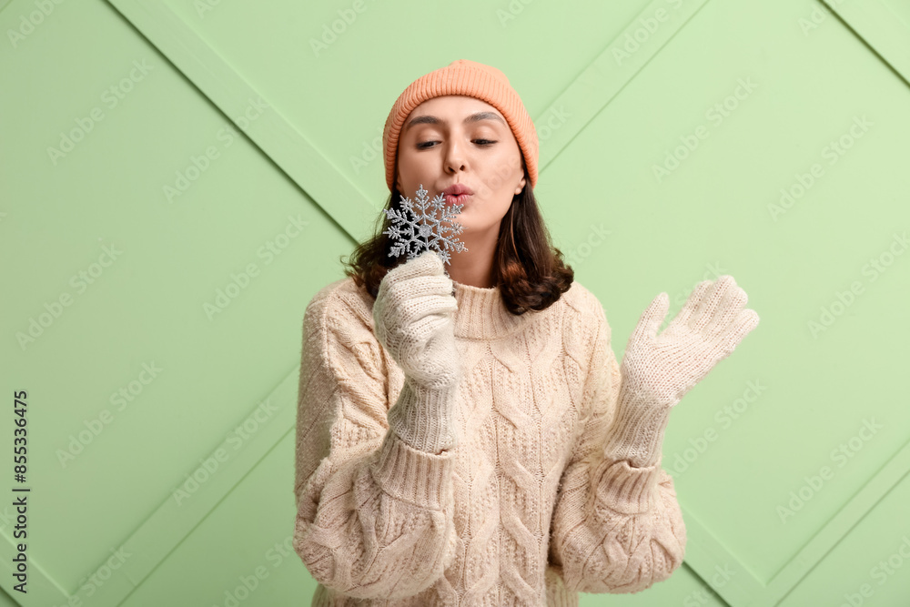 Wall mural beautiful young woman with decorative snowflake on green background