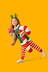 Cute little girl with teddy bear and Christmas cushion on color background