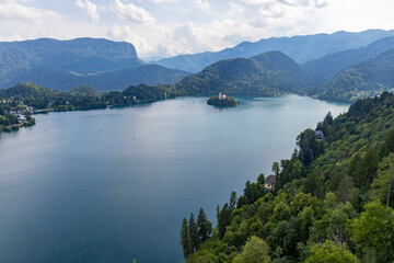 Obraz premium Panoramic view from Lake Bled, beauty heritage in Slovenia. Island with church and castle in the background create a dream setting. View from the castle, museum and court.
