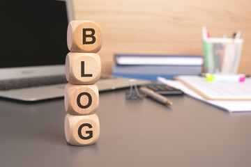 the word blog written on wooden cubes against computer keyboard background