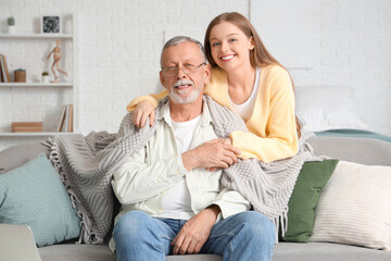 Female caregiver hugging senior man in nursing home