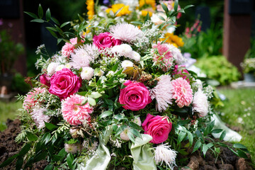 Vibrant flowers on fresh grave, symbolizing love and remembrance post-burial