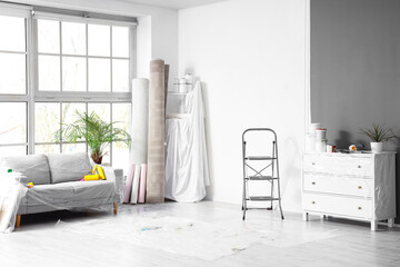 Covered sofa with repair tools in room