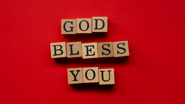 a yellow warm background without shadows wooden cubes with black letters laid out word god bless you