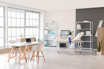 Interior of medical office with tables, couch and shelf units
