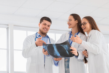 Young doctors studying x-ray image of lungs in clinic