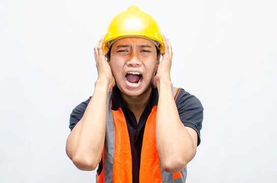 stressed overworked concept illustrated by asian male construction worker in orange vest and yellow safety helmet with furious, mad, sad, angry expression. 