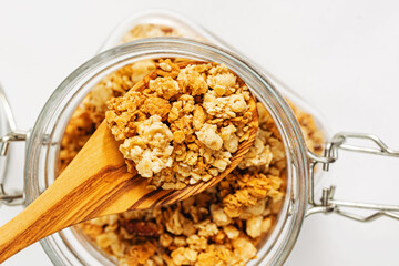 Jar of granola and wooden spoon, overhead view
