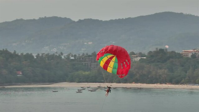 twilight time phuket island beach bay tourist parasailing flight aerial panorama 4k thailand