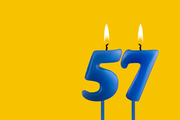 Blue candle number 57 - Birthday on yellow background