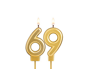 Golden number 69 birthday candle on white background