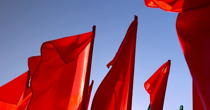red flags set up during the celebration in windy weather, flags flutter in the wind in spring