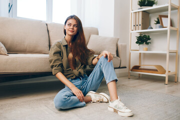 Happy Woman Relaxing on a Cosy Sofa in a Modern Apartment