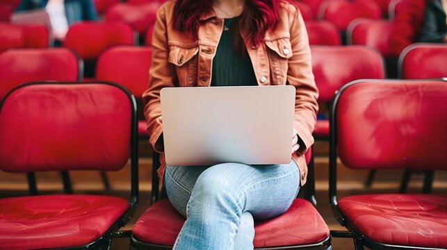 Individual reflecting with laptop in conference chair, fostering personal growth at corporate event