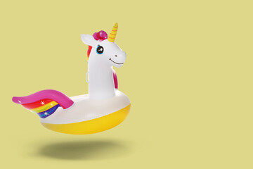 Stylish inflatable unicorn shaped ring in air on beige background. Space for text © New Africa