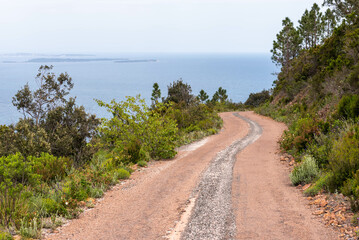 Road in the middle of the Esterel volcanic massif with the Mediterranean Sea in background (Saint-Raphael, Var, Provence-Alpes-Cote-d&rsquo;Azur, France)
