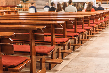 wooden benches in the church, holy mass, foreground sharp blurred background