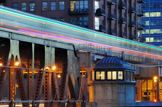 Streaked lights from a passing CTA elevated train as it leaves the Chicago Loop toward the city's west side on the Lake Street Bridge spanning the Chicago River.